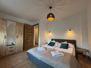 a bedroom with two beds and a chandelier at Pokoje Gościnne MAGNAS in Poronin
