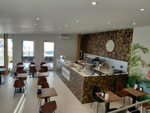 a restaurant with a counter and tables and chairs at Hotel Elys in Pieve Emanuele
