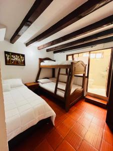 a bedroom with two bunk beds in a room at Hospedería Villa Lucía in Villa de Leyva