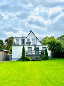 a white house with a green lawn in front of it at Lieblingsplatz in Kappeln