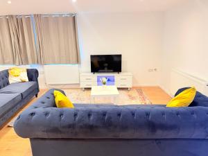a living room with a blue couch and a tv at Pear Barn Haven in Wisbech Saint Mary