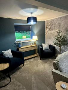 a living room with two couches and a flat screen tv at BROOMBANK, Melrose in Gattonside
