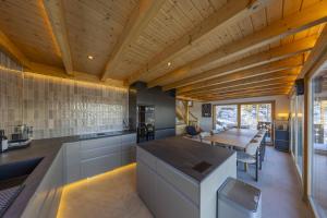 a kitchen with a wooden ceiling and a dining table at Chalet Nid Blanc in Nendaz