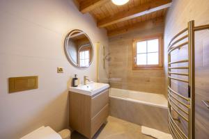 a bathroom with a sink and a tub and a toilet at Chalet Nid Blanc in Nendaz +28 photos