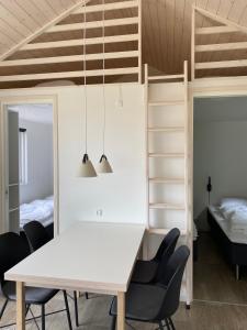 a dining room with a white table and chairs and a bunk bed at Rosenvold Strand Camping in Stouby