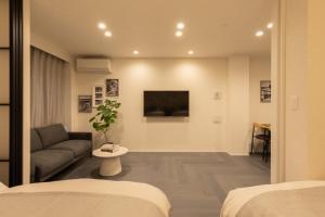 a living room with a couch and a tv at Hotel Kototoi East in Tokyo