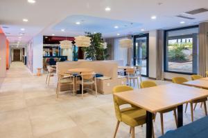 a restaurant with tables and chairs and windows at Stephouse Pozuelo Europa in Madrid