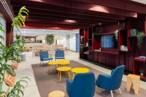 an office lobby with yellow tables and blue chairs at Stephouse Pozuelo Europa in Madrid