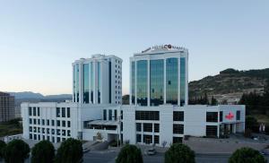 due edifici bianchi con un cartello sopra di Ramada Plaza By Wyndham Kahramanmaras a Kahramanmaraş