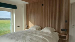 a bedroom with a large bed and a large window at Gîte du Coupiat in Walcourt