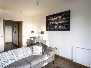 a living room with a couch and a painting on the wall at Royal Gardens Apartment 10 in Dornoch