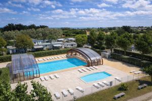 an overhead view of a swimming pool with lounge chairs and a swimming pool at ULVF Les Beaupins in Saint-Denis-dʼOléron