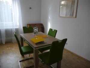 una mesa de comedor con sillas verdes en una habitación en Schöne Ferien und Messewohnung Nähe Düsseldorf und Köln, en Haan