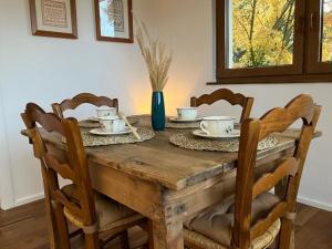 a dining room table with chairs and a wooden table with cups at Gite du Ried in Bischwiller +3 photos