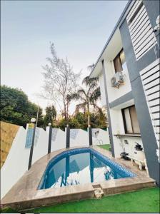 a swimming pool in front of a house at Shalimar Villa-2 in Jāmb