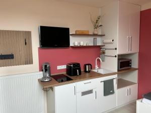 a kitchen with a counter with a tv on the wall at Gästezimmer am Lippesee - Apartements mit Küche - Perfekt für Langzeitaufenthalt in Paderborn