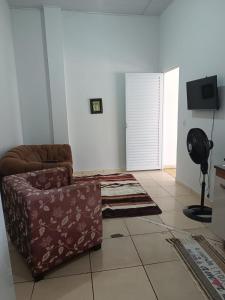 a living room with a couch and a television at Casa perto da Unemat in Cáceres