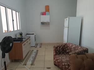 a kitchen with a couch and a refrigerator at Casa perto da Unemat in Cáceres