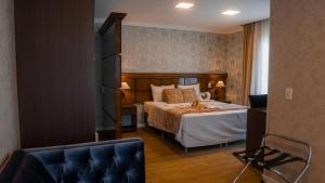 a hotel room with a bed and a chair at Hotel Gramado Interlaken in Gramado +155 photos