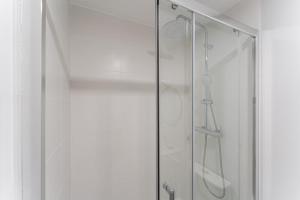 a shower with a glass door in a bathroom at GuestReady - Charming cosy home in Porto