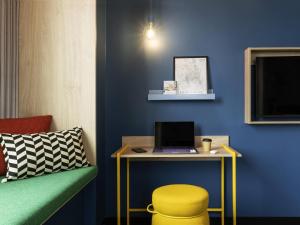a room with a desk with a laptop and a stool at ibis Styles Copenhagen Orestad in Copenhagen +56 photos
