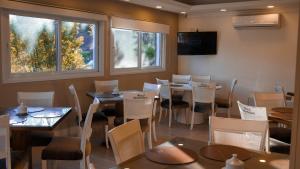 a dining room with tables and chairs and windows at Hotel Gramado Interlaken in Gramado