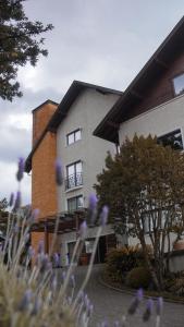 a building with purple flowers in front of it at Hotel Gramado Interlaken in Gramado