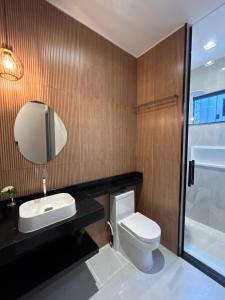 a bathroom with a toilet and a sink and a mirror at LD Smart Residence in Castanhal +3 photos