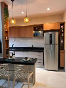a kitchen with a refrigerator and a table and chairs at LD Smart Residence in Castanhal