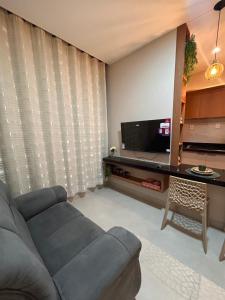 a living room with a couch and a television at LD Smart Residence in Castanhal