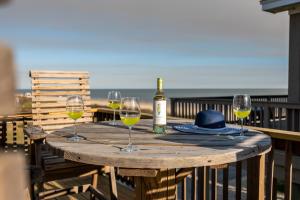 a table with three glasses of wine and a hat at Ocean View l Pet Friendly in Gilchrist