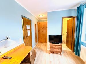 a living room with a tv on a wooden table at Hotel Pelli Hof Rendsburg by Tulip Inn in Rendsburg +23 photos