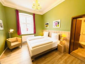 a bedroom with a bed and a chair and a window at Hotel Pelli Hof Rendsburg by Tulip Inn in Rendsburg