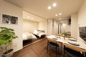 a bedroom with a bed and a dining room with a table at Hotel Kototoi East in Tokyo