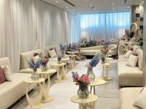 ein Wartezimmer mit Sofas und Blumen auf Tischen in der Unterkunft Paradise Nice Hotel Jeddah in Dschidda + 48 Fotos