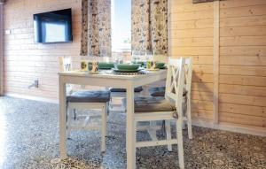 a dining room table with chairs and a white table and chairsktop at z widokiem na zalew in Sułomino