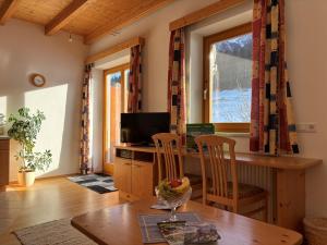 a living room with a table and a television at Bauernhof Ober in Birnbaum