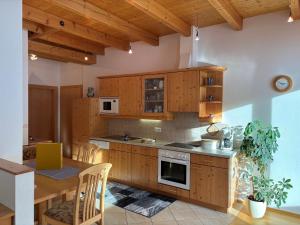 a kitchen with wooden cabinets and a wooden table with a dining room at Bauernhof Ober in Birnbaum