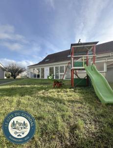a playground with a slide in front of a house at Le Gite Zoé in Bourbourg