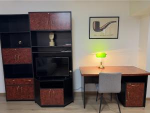 a room with a desk and a tv and a cabinet at Summit Ultracentral in Baia Mare