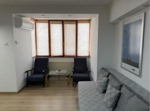 a living room with a couch and two chairs and a table at Summit Ultracentral in Baia Mare