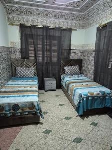 a bedroom with two beds and a ceiling at Appartement familial villa 110 m2 jardin et piscine in Meknès