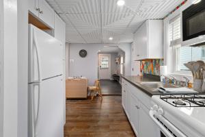 a kitchen with white cabinets and a white refrigerator at Salisbury Surf Pet Friendly 1 Block to Beach in Salisbury