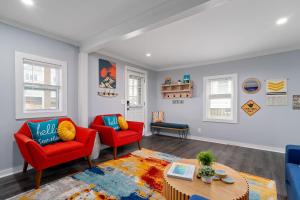 a living room with two red chairs and a table at Salisbury Surf Pet Friendly 1 Block to Beach in Salisbury