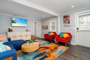 a living room with a blue couch and red chairs at Salisbury Surf Pet Friendly 1 Block to Beach in Salisbury