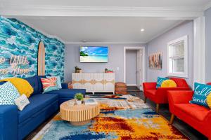 a living room with a blue couch and red chairs at Salisbury Surf Pet Friendly 1 Block to Beach in Salisbury +42 photos