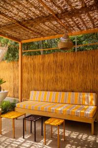 a couch and two stools under a pergola at Sama Lodge in Saly Portudal