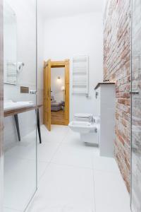 een badkamer met een bakstenen muur, een wastafel en een toilet bij Antique Apartments Plac Szczepański in Krakau