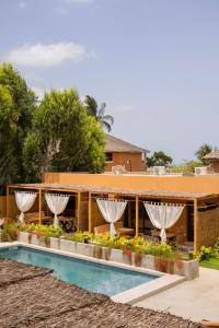 a resort with a swimming pool and a building at Sama Lodge in Saly Portudal