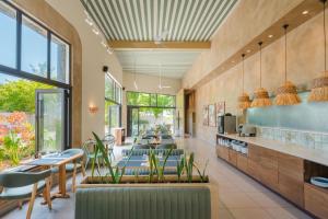 a restaurant with chairs and tables and windows at Be Cosy by LOV Mauritius in Trou aux Biches